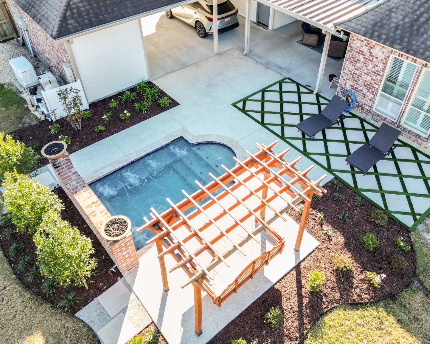 A finished backyard with a pool and structured landscape beds